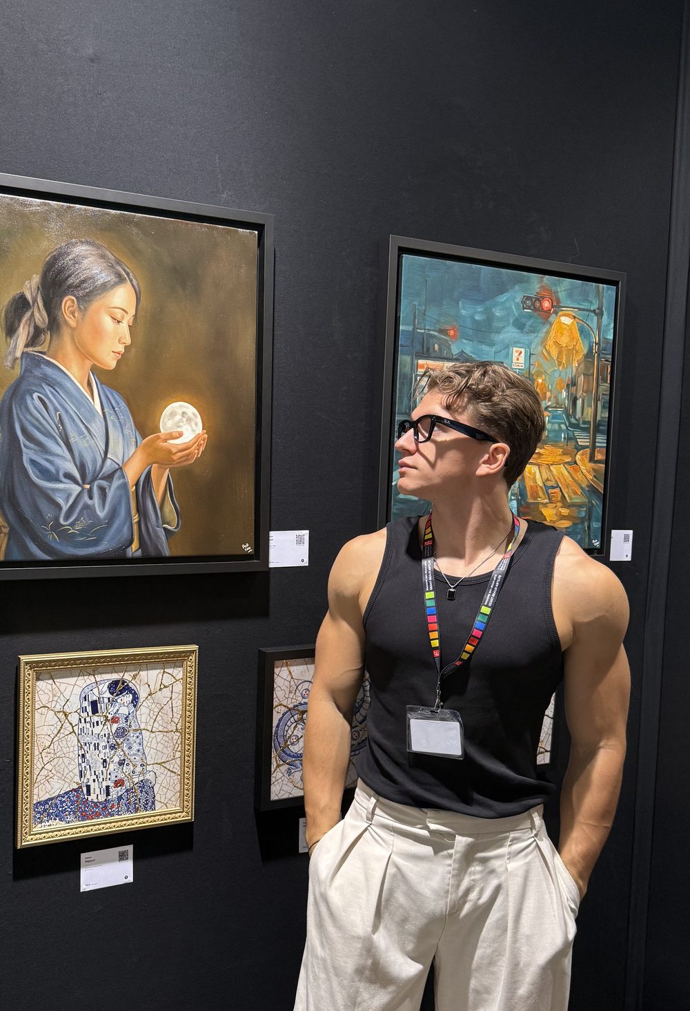William San, en débardeur noir et lunettes, sur le stand de l’Atelier Joconde, lève les yeux vers Tsuki, une femme en kimono bleu qui tient une lune entre ses mains.